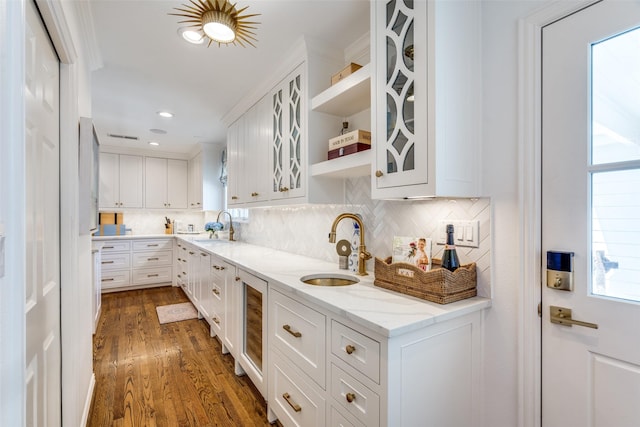 kitchen featuring decorative backsplash, a sink, dark wood-type flooring, and white cabinetry