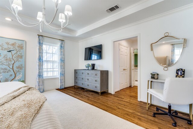 bedroom with crown molding, wood finished floors, a chandelier, baseboards, and visible vents