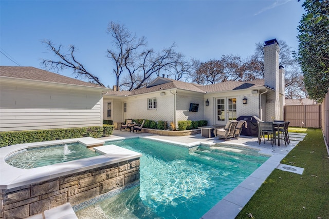 view of swimming pool with fence, a patio area, a fenced in pool, and an in ground hot tub
