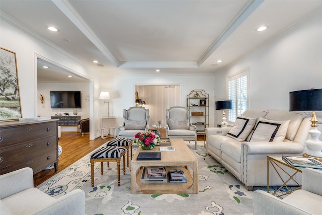 living area with a tray ceiling, recessed lighting, light wood-style floors, and ornamental molding
