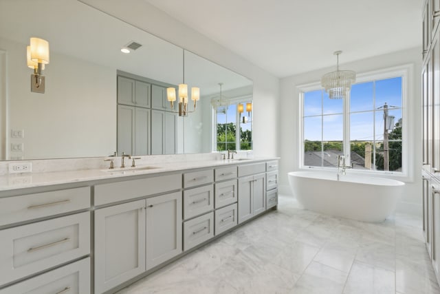 9518 Still Creek Ln, Dallas, TX 75238 - full bathroom with a chandelier, marble finish floors, double vanity, and a freestanding tub