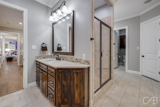 bathroom with ornamental molding, toilet, a shower stall, vanity, and tile patterned floors