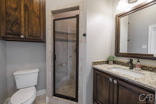 full bath featuring toilet, vanity, a shower stall, and tile patterned flooring