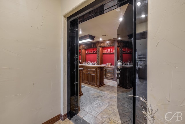interior space with baseboards, vanity, and stone finish floor