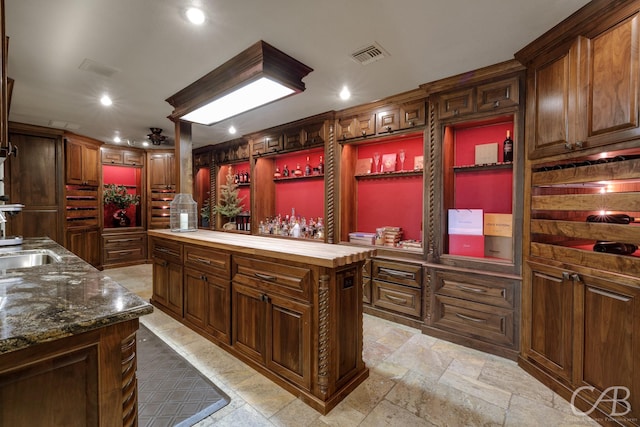 kitchen featuring visible vents, recessed lighting, open shelves, wood counters, and a kitchen island