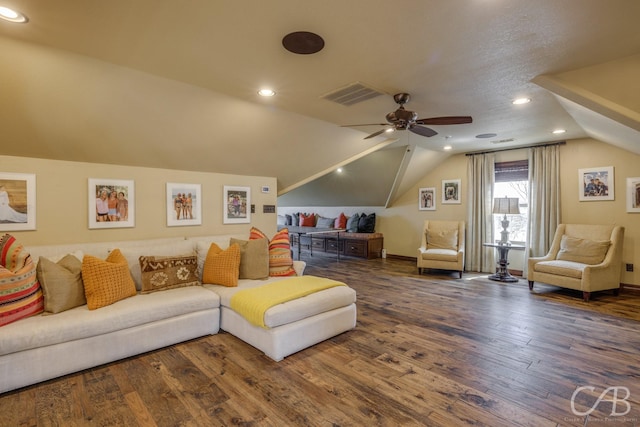 living area with lofted ceiling, visible vents, hardwood / wood-style flooring, and ceiling fan