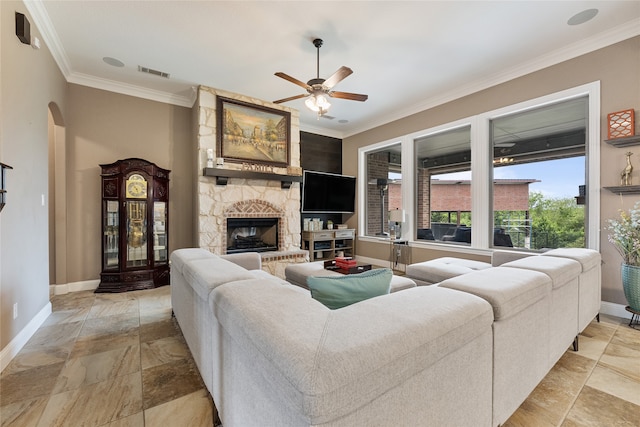 living area featuring baseboards, ornamental molding, a ceiling fan, and visible vents