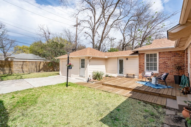 view of yard with driveway, a garage, fence, and a deck