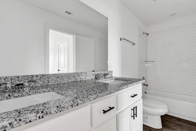 2616 S Fannin Ave, Denison, TX 75020 - bathroom featuring visible vents, wood finished floors, toilet, and a sink