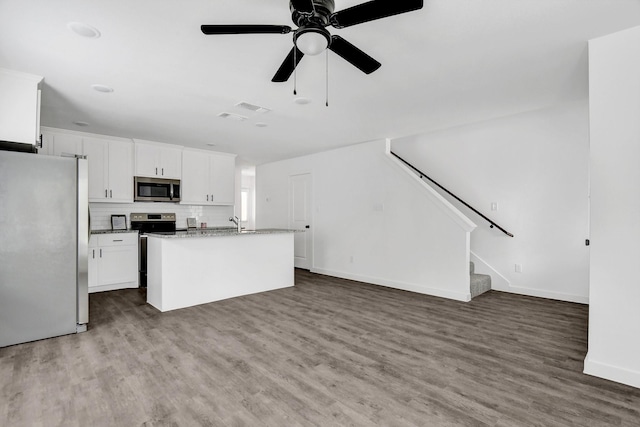 2616 S Fannin Ave, Denison, TX 75020 - kitchen featuring decorative backsplash, white cabinetry, wood finished floors, and stainless steel appliances
