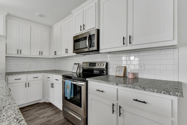 2616 S Fannin Ave, Denison, TX 75020 - kitchen with white cabinets, decorative backsplash, light stone counters, and stainless steel appliances