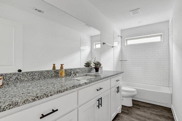 2616 S Fannin Ave, Denison, TX 75020 - full bath with toilet, visible vents, wood finished floors, and vanity