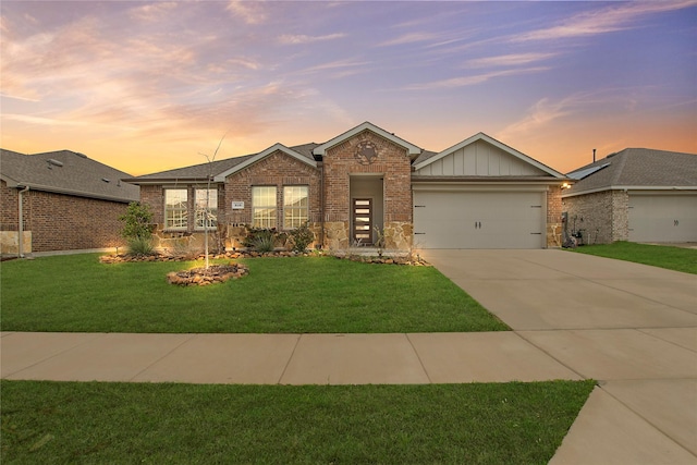 616 Bunker Hill Rd, Fate, TX 75189 - view of front of house featuring board and batten siding, brick siding, a garage, concrete driveway, and a front lawn