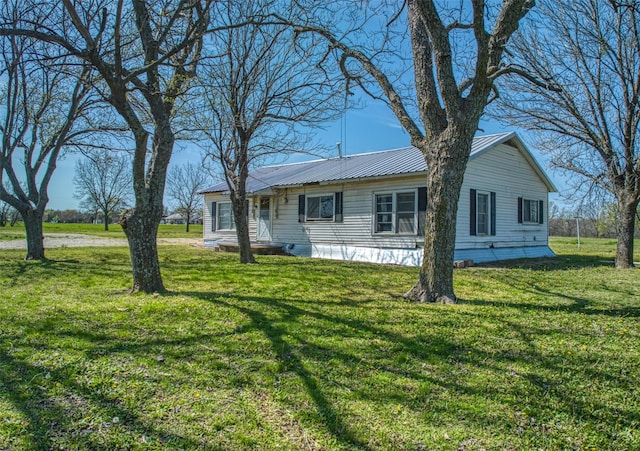 view of front facade featuring metal roof and a front yard