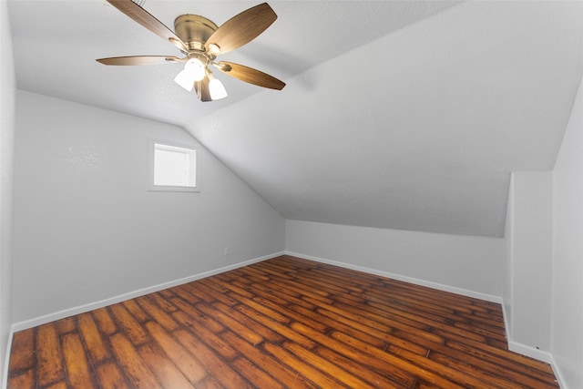 bonus room with baseboards, lofted ceiling, dark wood-style floors, and ceiling fan