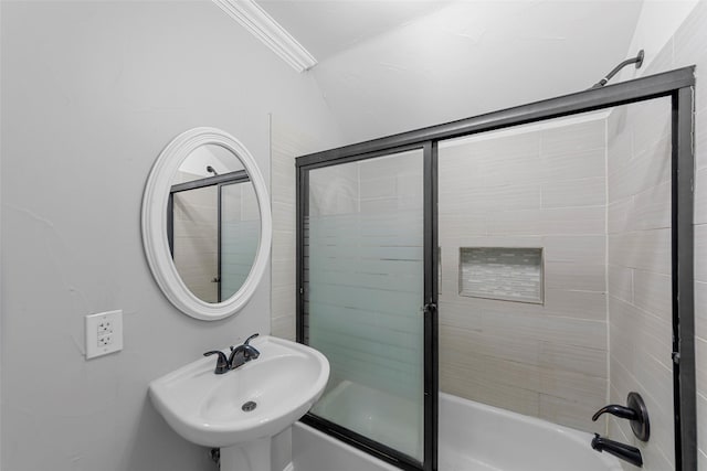 full bathroom featuring combined bath / shower with glass door, a sink, and ornamental molding