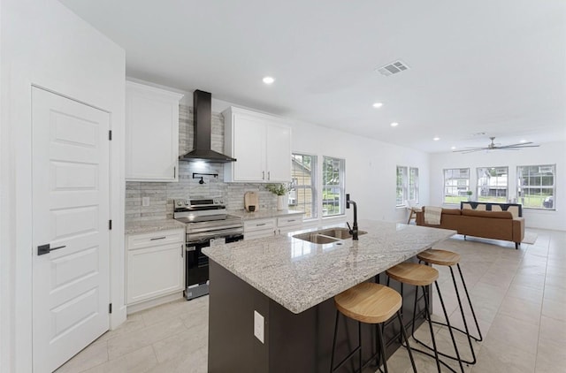 318 Whitworth St, Sulphur Springs, TX 75482 - kitchen featuring decorative backsplash, stainless steel range with electric stovetop, a sink, a wealth of natural light, and wall chimney range hood