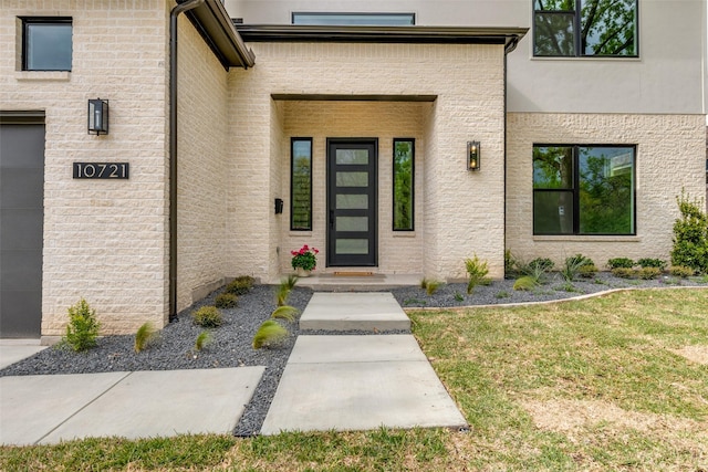 property entrance featuring a lawn and stucco siding