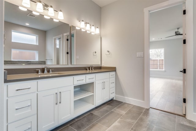 bathroom featuring a sink, baseboards, a healthy amount of sunlight, and visible vents