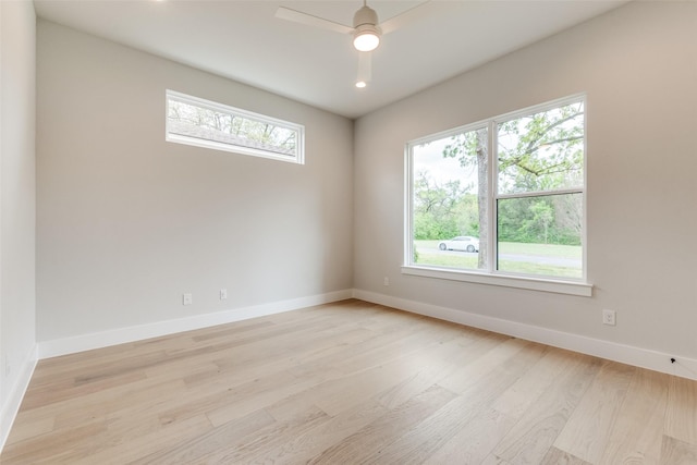 unfurnished room with a wealth of natural light, baseboards, and light wood-type flooring