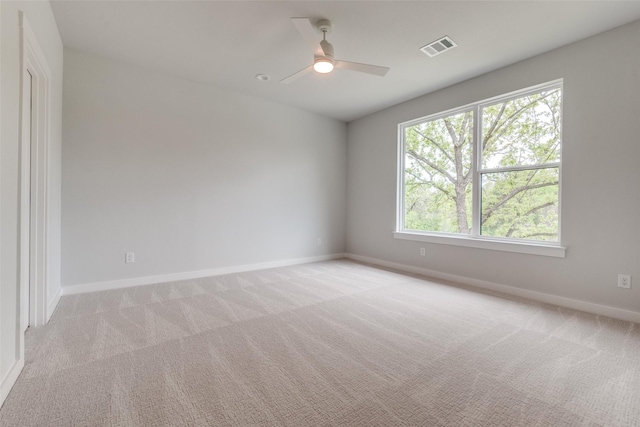 spare room with baseboards, light colored carpet, and ceiling fan