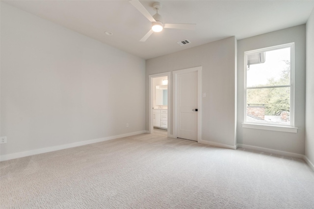 empty room featuring light carpet, baseboards, visible vents, and a ceiling fan