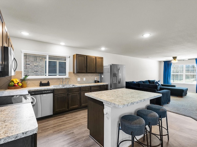 6348 Sloop St, Fort Worth, TX 76179 - kitchen featuring light countertops, a sink, a breakfast bar area, and appliances with stainless steel finishes
