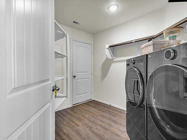 6348 Sloop St, Fort Worth, TX 76179 - clothes washing area with visible vents, baseboards, wood finished floors, laundry area, and washer and dryer