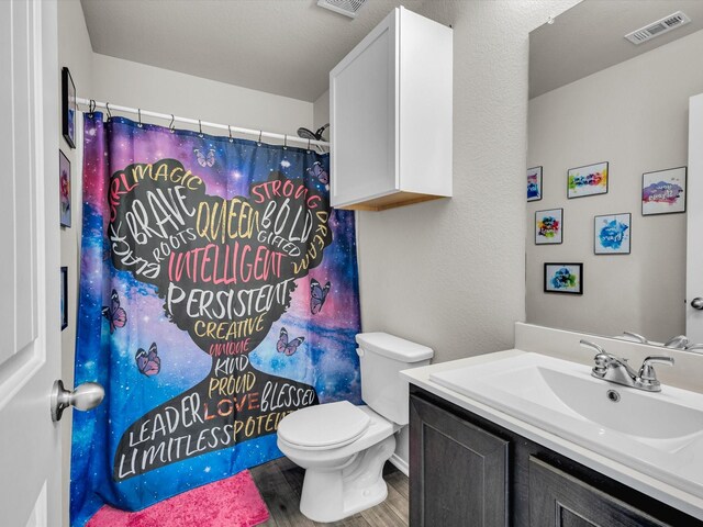 6348 Sloop St, Fort Worth, TX 76179 - bathroom with toilet, vanity, a shower with curtain, wood finished floors, and visible vents