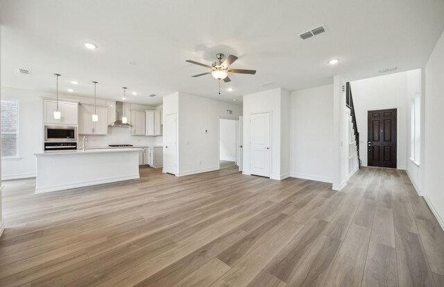 244 Kistler Dr, Little Elm, TX 76227 - unfurnished living room featuring a ceiling fan, recessed lighting, light wood finished floors, baseboards, and a sink