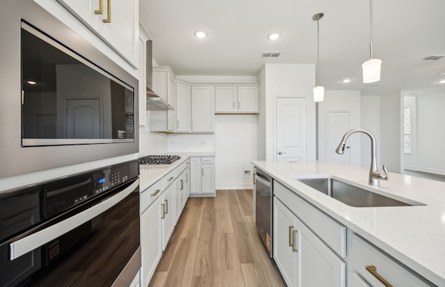 244 Kistler Dr, Little Elm, TX 76227 - kitchen with appliances with stainless steel finishes, a sink, pendant lighting, light stone countertops, and light wood-type flooring