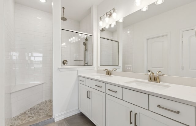 full bath with walk in shower, double vanity, and a sink