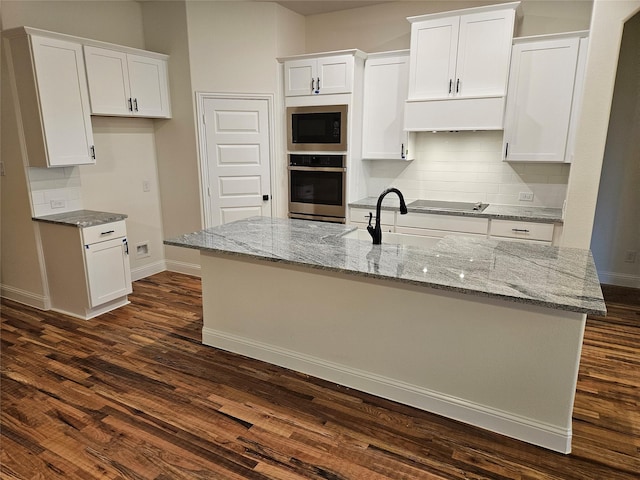 kitchen with white cabinetry, built in microwave, stainless steel oven, and a sink