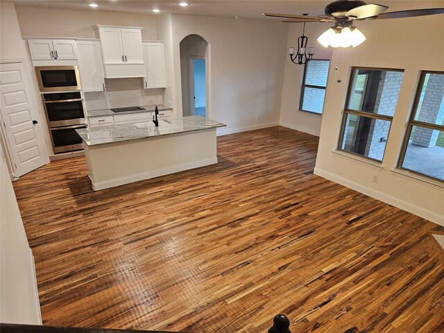 kitchen with white cabinetry, dark wood-type flooring, arched walkways, a ceiling fan, and appliances with stainless steel finishes