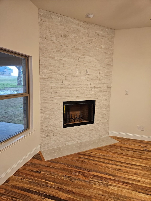 room details with baseboards, a fireplace, and wood finished floors