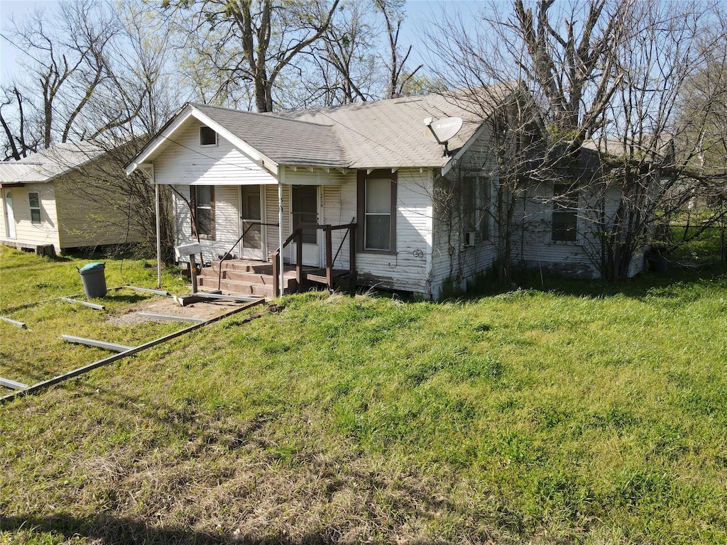 214 W Main, Fairfield, TX 75840 - view of front facade featuring covered porch, a front lawn, and roof with shingles