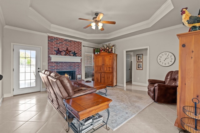living area featuring a ceiling fan, a raised ceiling, light tile patterned flooring, and crown molding