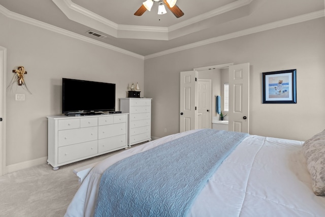 bedroom featuring light colored carpet, ornamental molding, baseboards, a raised ceiling, and visible vents
