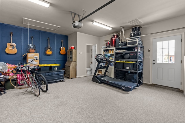 workout room with attic access, visible vents, carpet floors, and a garage