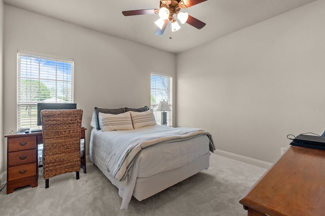bedroom featuring light carpet, baseboards, and ceiling fan