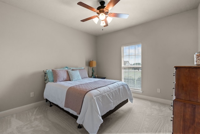 bedroom featuring baseboards, a ceiling fan, and light colored carpet