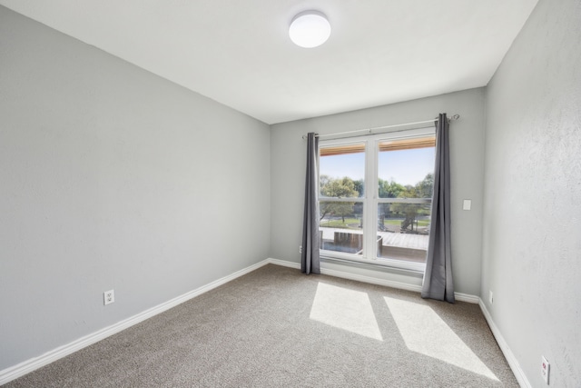 unfurnished room featuring baseboards and carpet