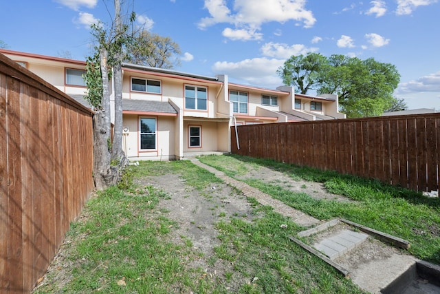 back of house featuring stucco siding and fence