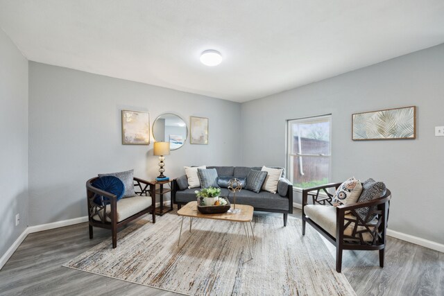 living area with baseboards and wood finished floors