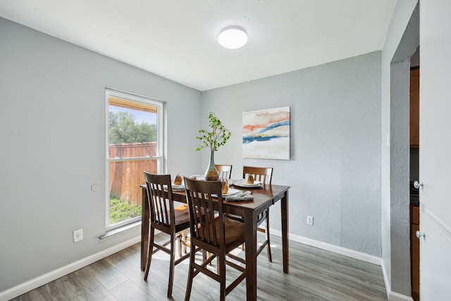 dining space featuring baseboards and wood finished floors