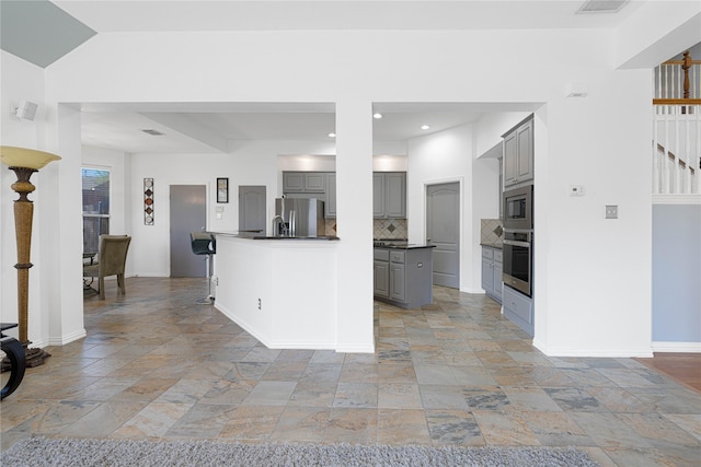 1808 Paddington Ct, Arlington, TX 76017 - kitchen featuring stainless steel appliances, gray cabinets, stone tile floors, dark countertops, and recessed lighting