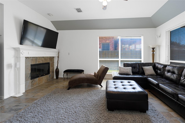 1808 Paddington Ct, Arlington, TX 76017 - living area featuring vaulted ceiling, stone tile flooring, healthy amount of natural light, and a tile fireplace