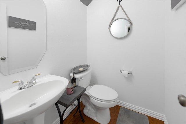 1808 Paddington Ct, Arlington, TX 76017 - bathroom with a sink, wood finished floors, toilet, and baseboards