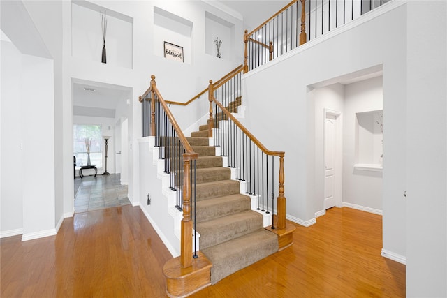 1808 Paddington Ct, Arlington, TX 76017 - staircase with wood finished floors, a towering ceiling, and baseboards