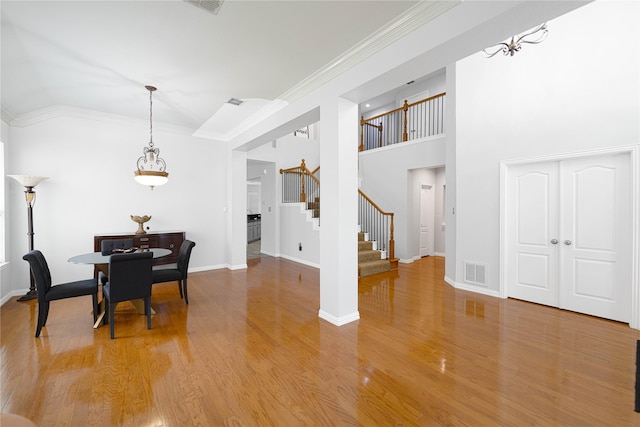 1808 Paddington Ct, Arlington, TX 76017 - dining space featuring stairs, light wood-type flooring, ornamental molding, baseboards, and a high ceiling
